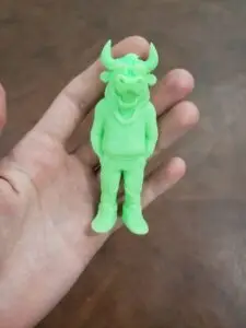 A neon green bull figurine, 3D printed by PlastiForge3D using SLA resin, showcasing intricate details and custom design features.