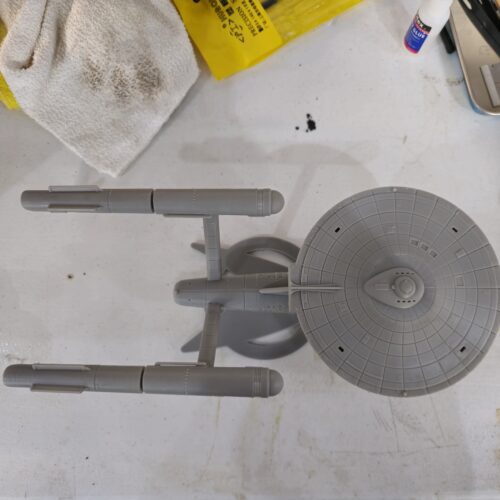 Top-down view of a gray resin 3D printed starship model inspired by Star Trek, showcasing intricate paneling and symmetrical nacelle layout.