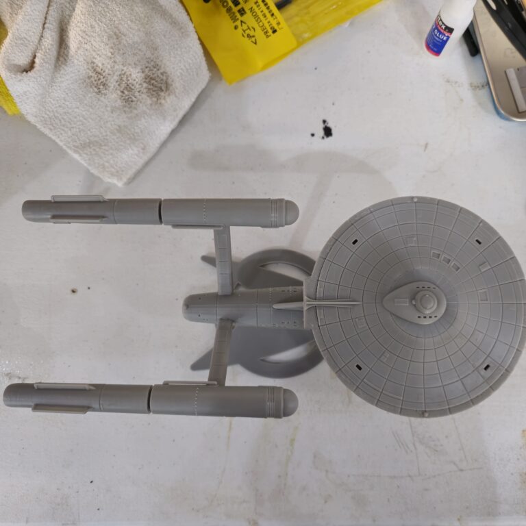 Top-down view of a gray resin 3D printed starship model inspired by Star Trek, showcasing intricate paneling and symmetrical nacelle layout.