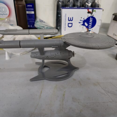 Side profile of a gray resin 3D printed spaceship model with a circular saucer and twin engine nacelles, printed by PlastiForge3D.