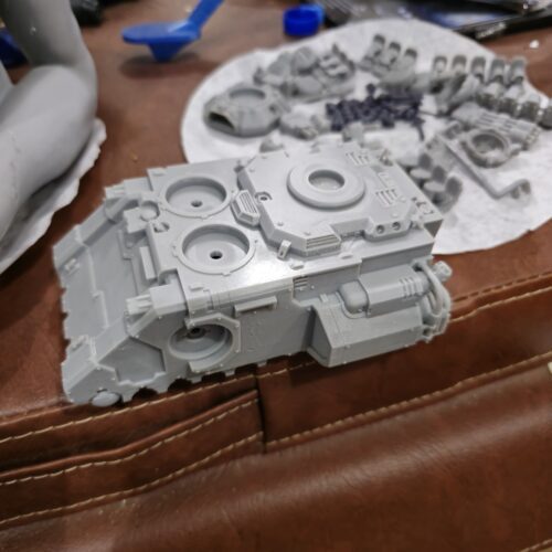 3D printed Gladiator tank body from the Warhammer universe, partially assembled with custom parts in the background, printed by PlastiForge3D.