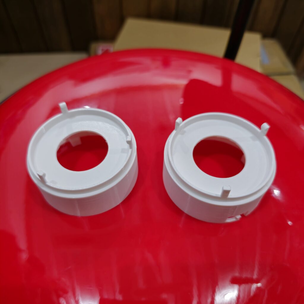 White 3D printed lamp adapters designed to convert between different bulb sizes, created using FDM printing by PlastiForge3D.