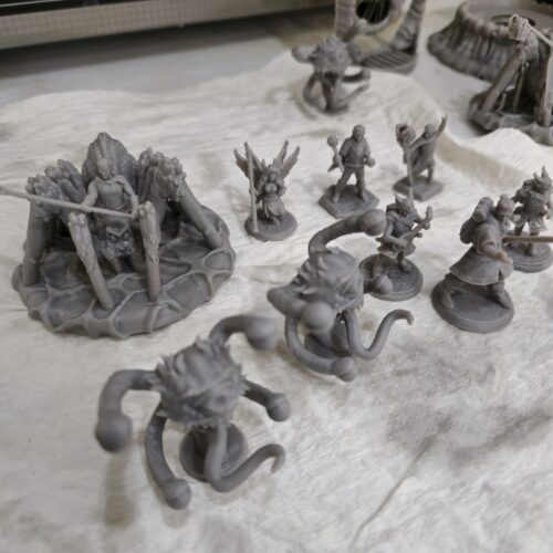 A set of resin-printed tabletop miniatures including fantasy heroes, spellcasters, and tentacled monsters, custom 3d printed by PlastiForge3D for RPG and board game use.