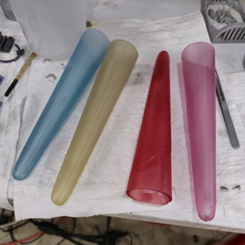 Four translucent resin cones for Power Rangers props in yellow, blue, red, and pink, custom made by PlastiForge3D.