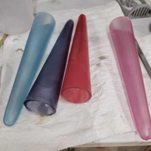 Four translucent MMPR cones in custom resin colors including blue, black, red, and pink, 3D printed as Power Rangers props.