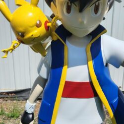 Close-up view of a life-size 3D printed statue of Ash Ketchum with Pikachu on his shoulder, showing detailed paint and craftsmanship.