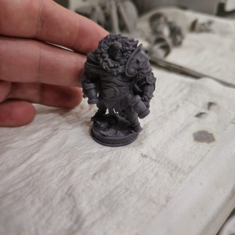 3D printing gallery detail of Hugo the Huge, an assembled DnD miniature with intricate armor and a textured base.