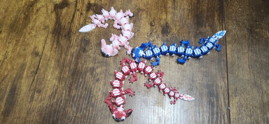 Stitch dragon fidget toy in red, blue, and pink displayed on wood surface